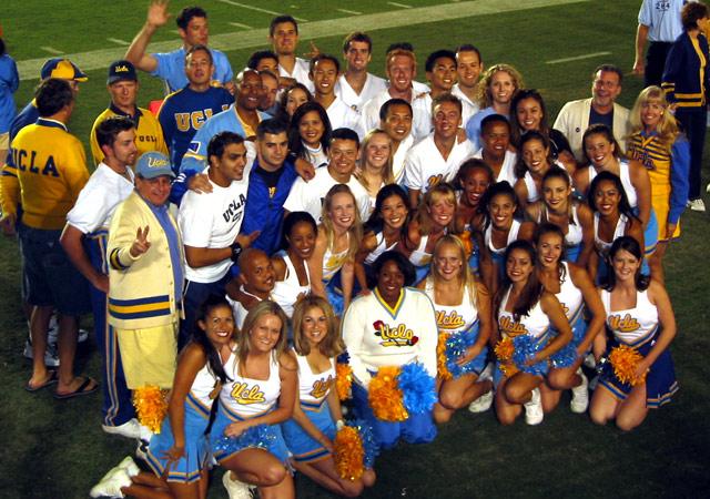 the 2003 Squad on the football field at the Homecoming game, posed with alumni of the Squad