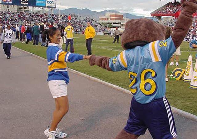 the 2000 Squad and Joe Bruin dancing on a football field